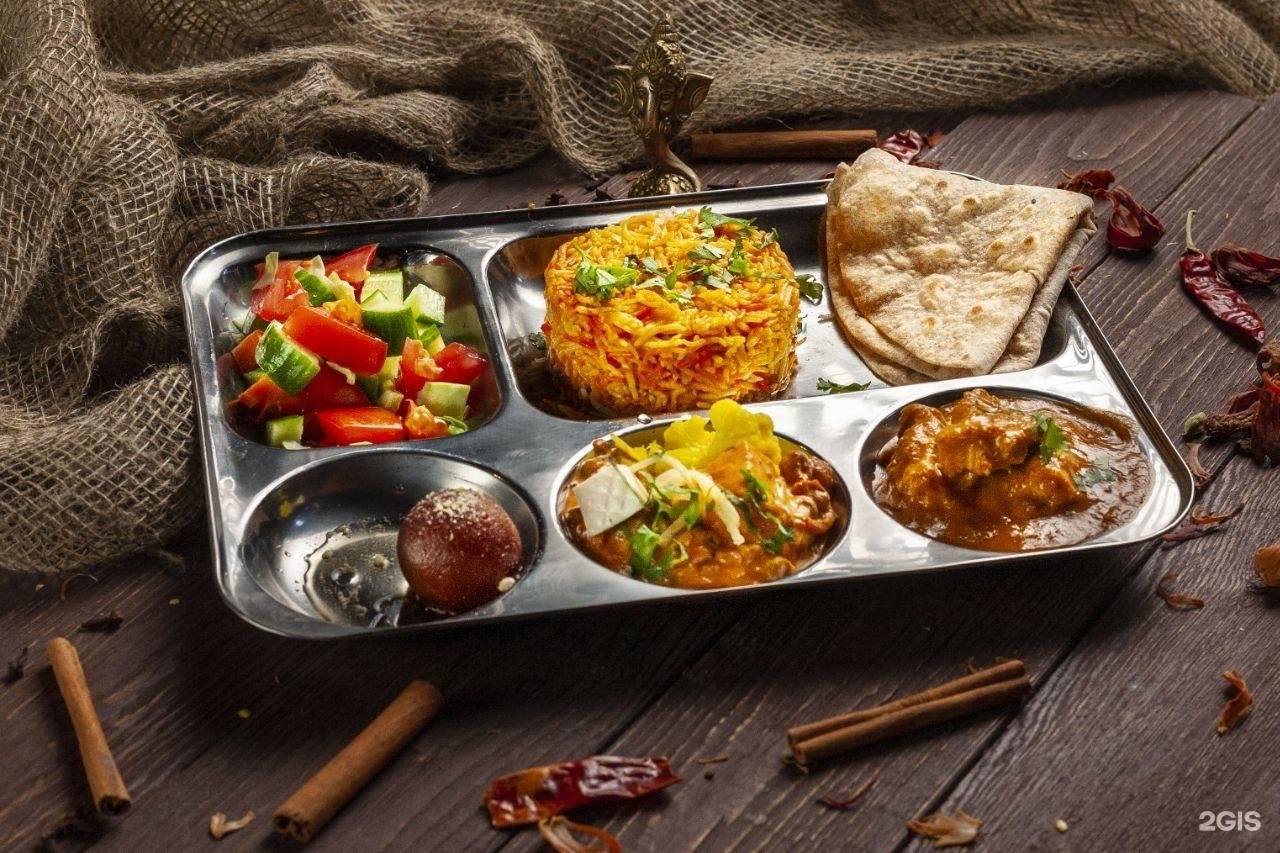 Ганеша спб. Ганеша индийский ресторан СПБ. Подноса с разнообразными блюдами.